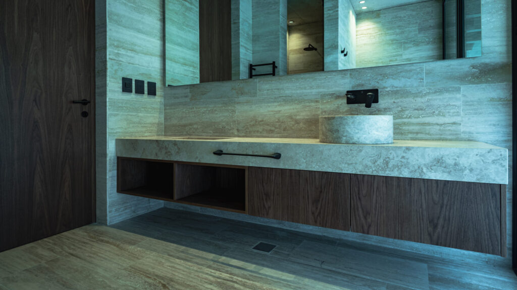 Casa Virazón II Baño con mueble suspendido en madera y mesada de piedra.
