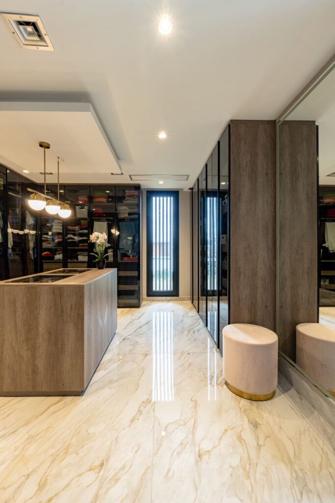 Casa Virazón I Vestidor con isla central para accesorios y guardado a medida.