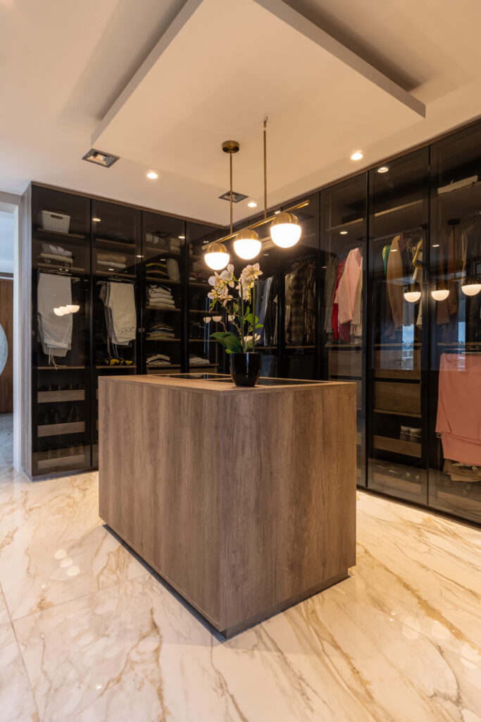 Casa Virazón I Vestidor con isla central para accesorios y guardado a medida.