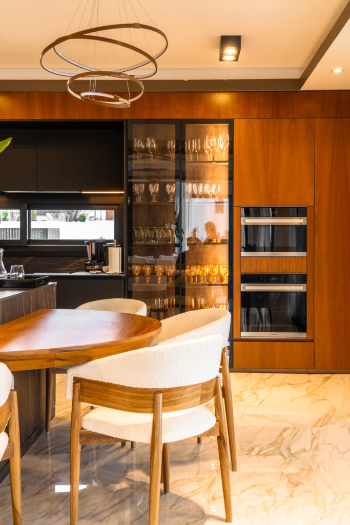 Casa Virazón I Isla de cocina con mesa integrada en madera enchapada.